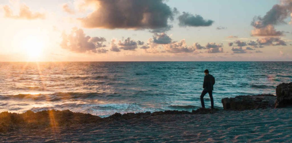 Men standing on beach to self understanding